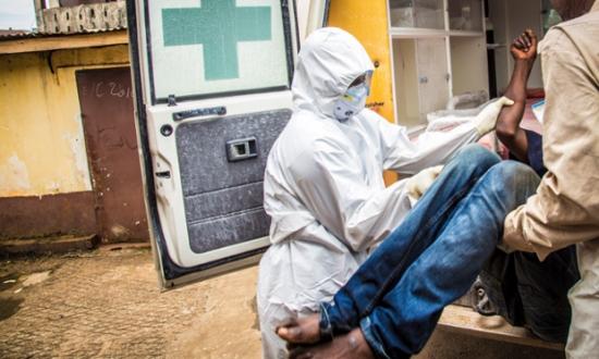 Red Cross workers load a suspected Ebola case into an ambulance in Freetown, Sierra Leone, in September. Freetown still has a relatively large number of cases. Photograph: Michael Duff/AP 